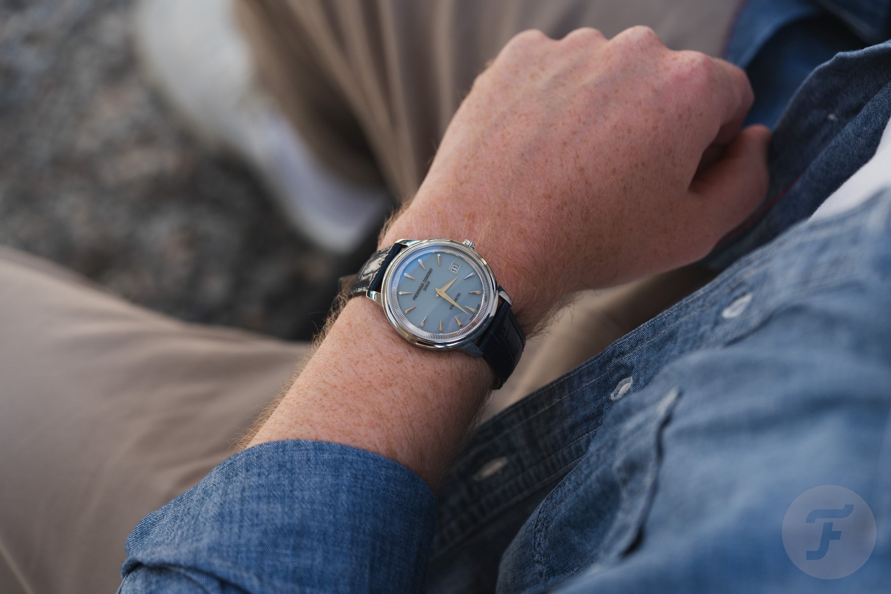 blue-dial Frederique Constant Moneta Solarmetre on wrist, over-shoulder shot