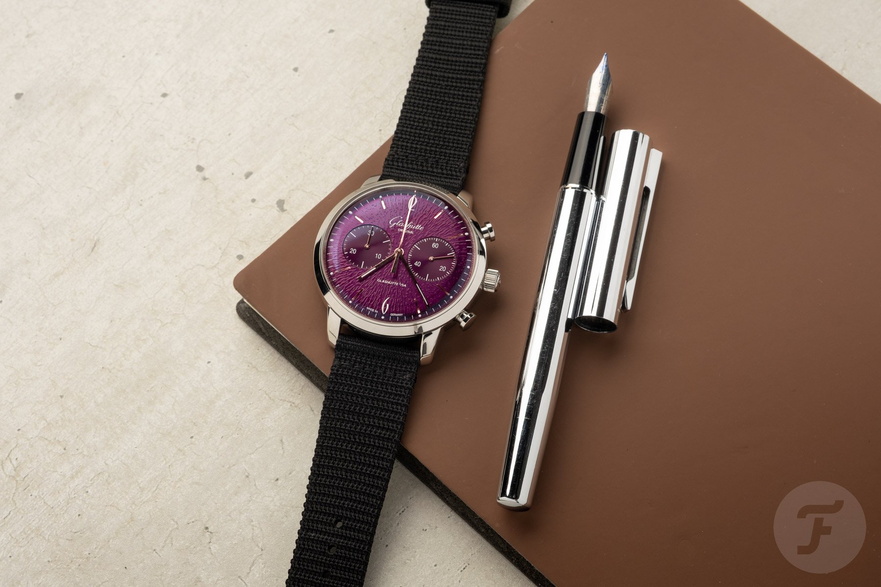 Glashütte Original Sixties Chronograph Annual Edition Purple flat-lay next to pen
