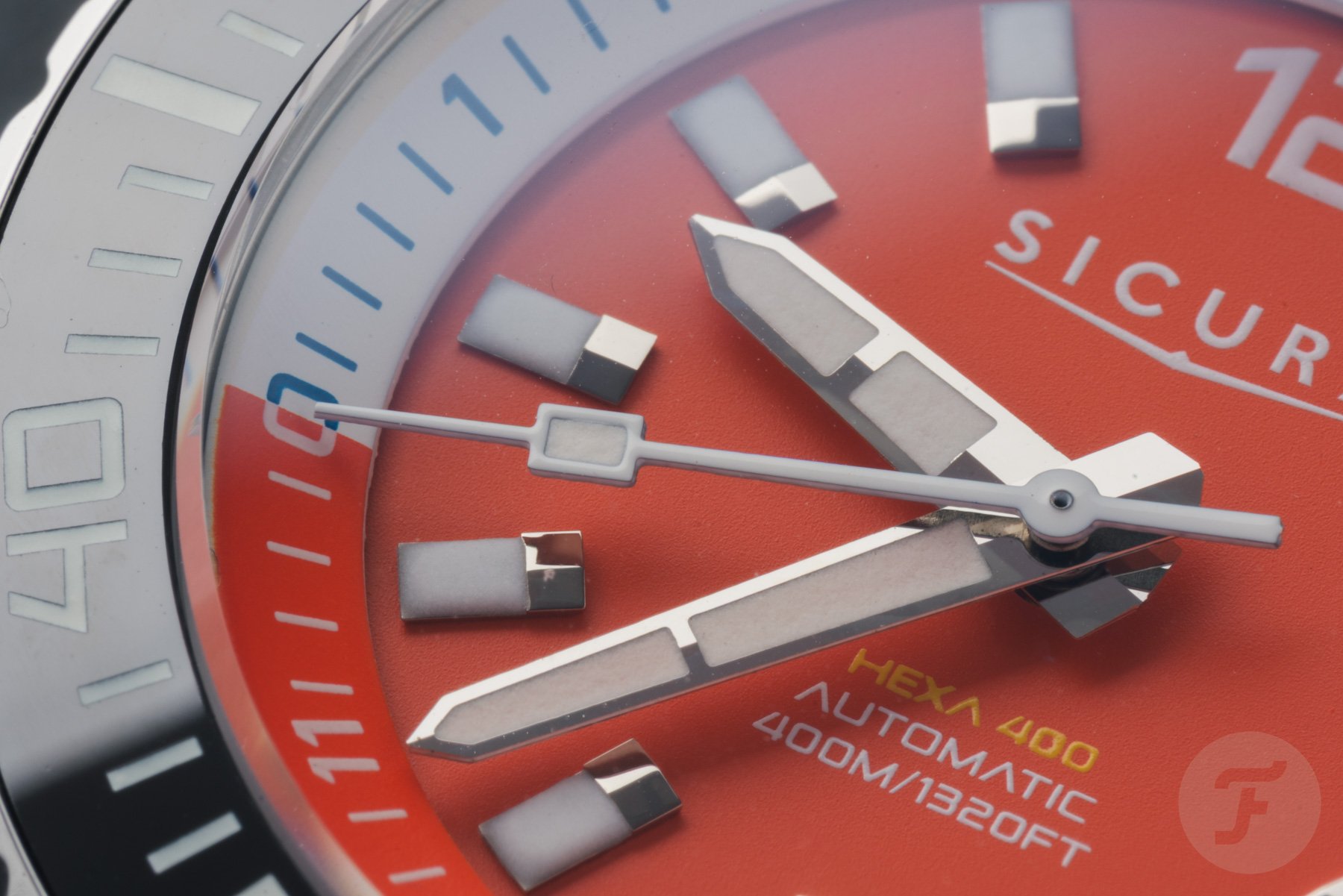 orange-dial Sicura Hexa 400 hands and indexes up close