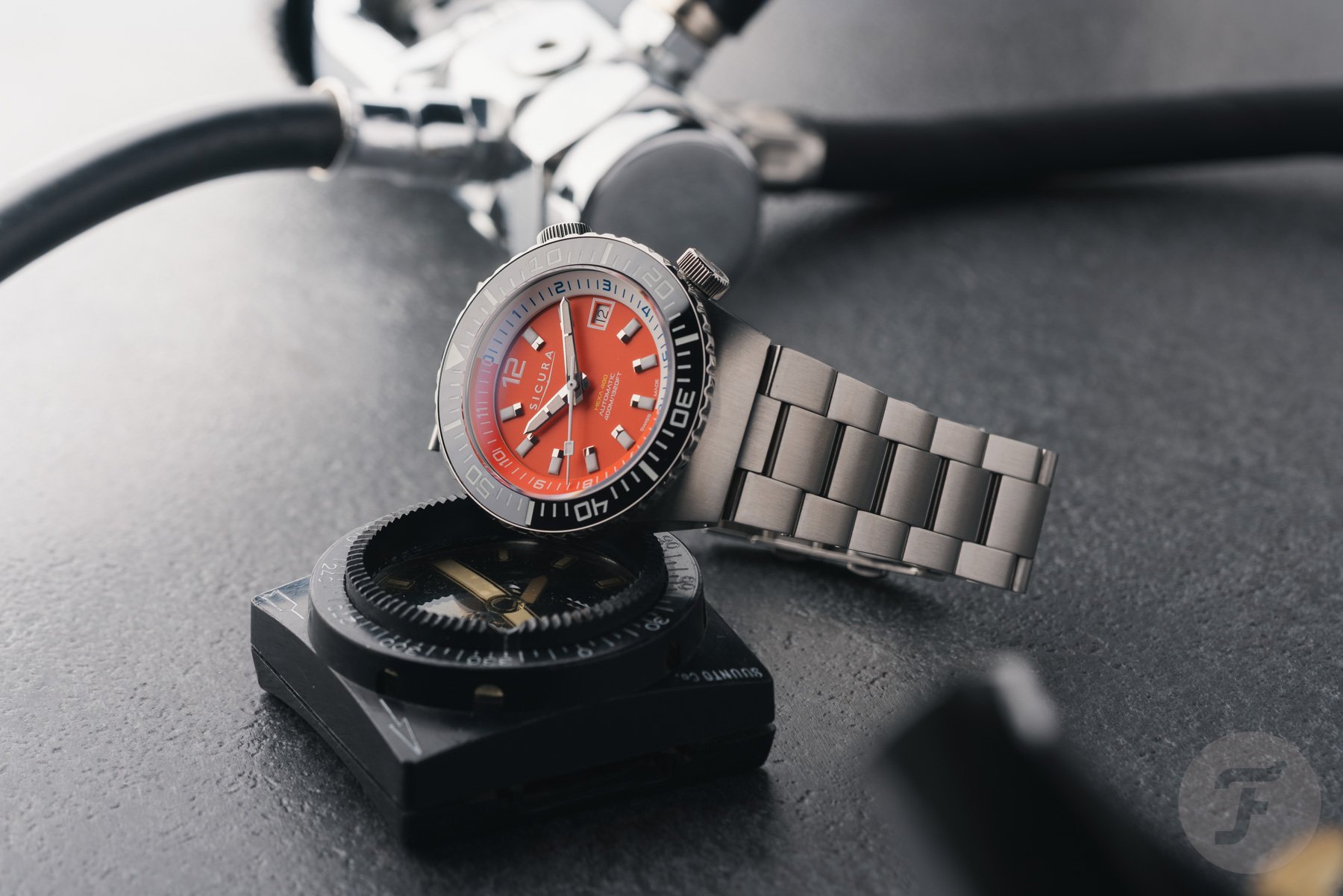 orange-dial Sicura Hexa 400 propped up on compass