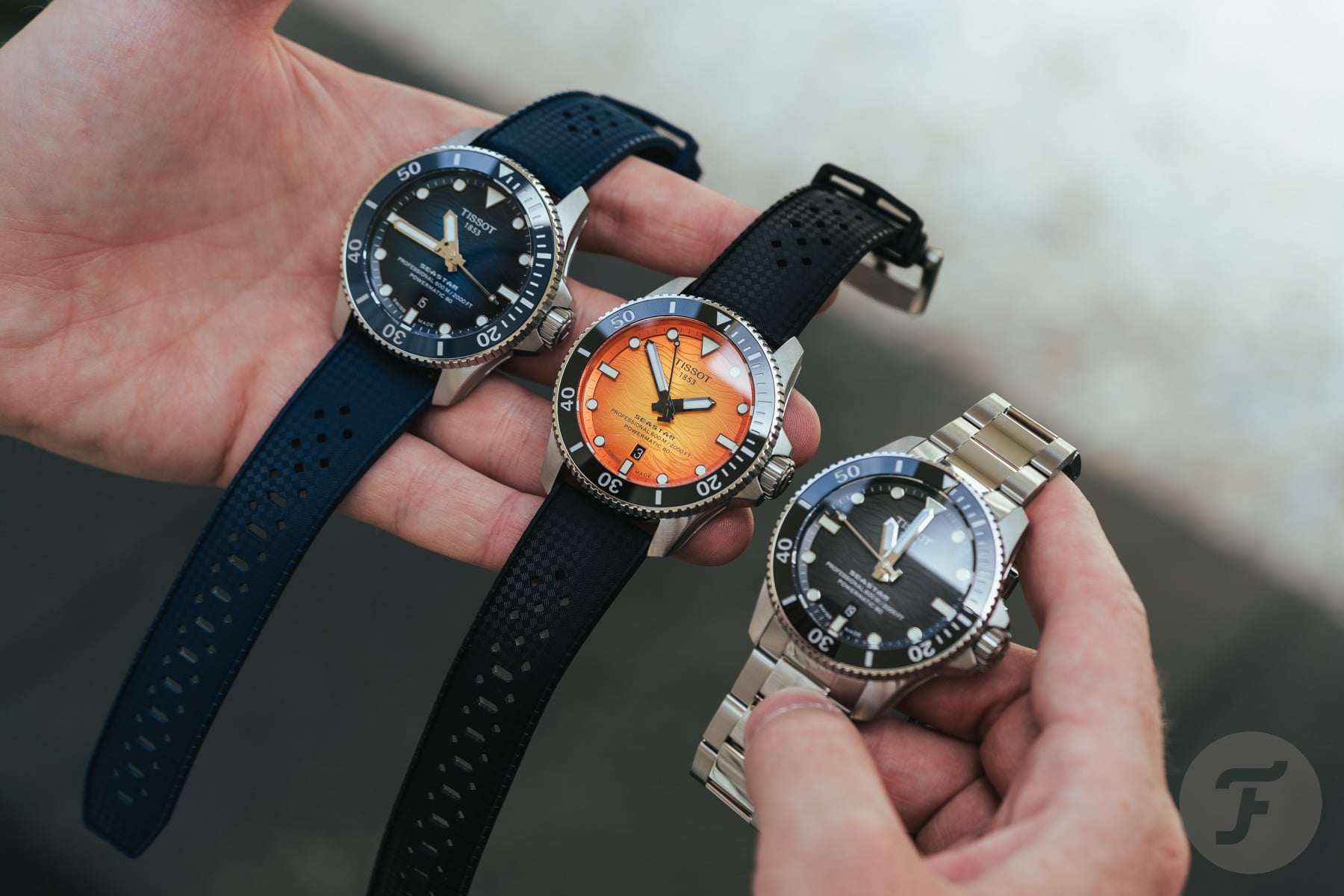Three versions of the sized-down Tissot Seastar 2000 Professional in hands