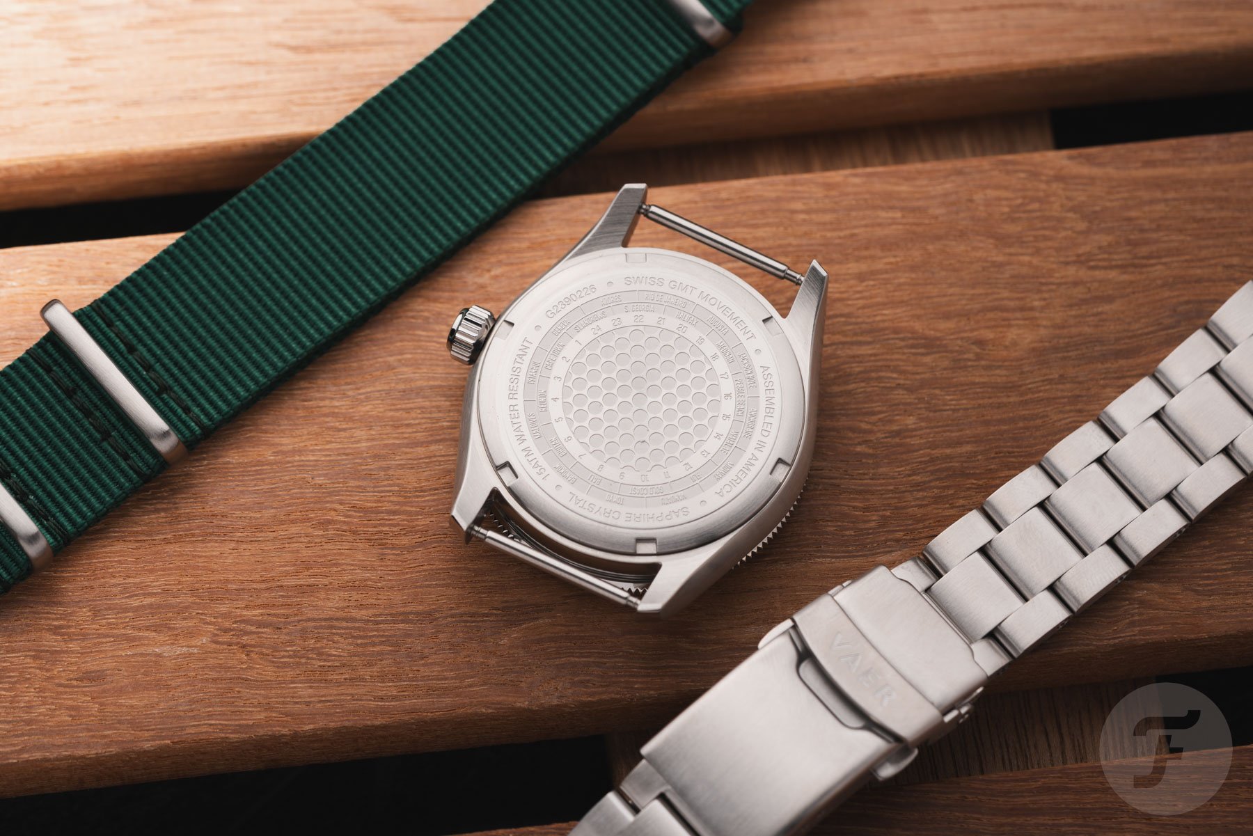 Vaer G2 Fairway GMT face down between green NATO strap and bracelet