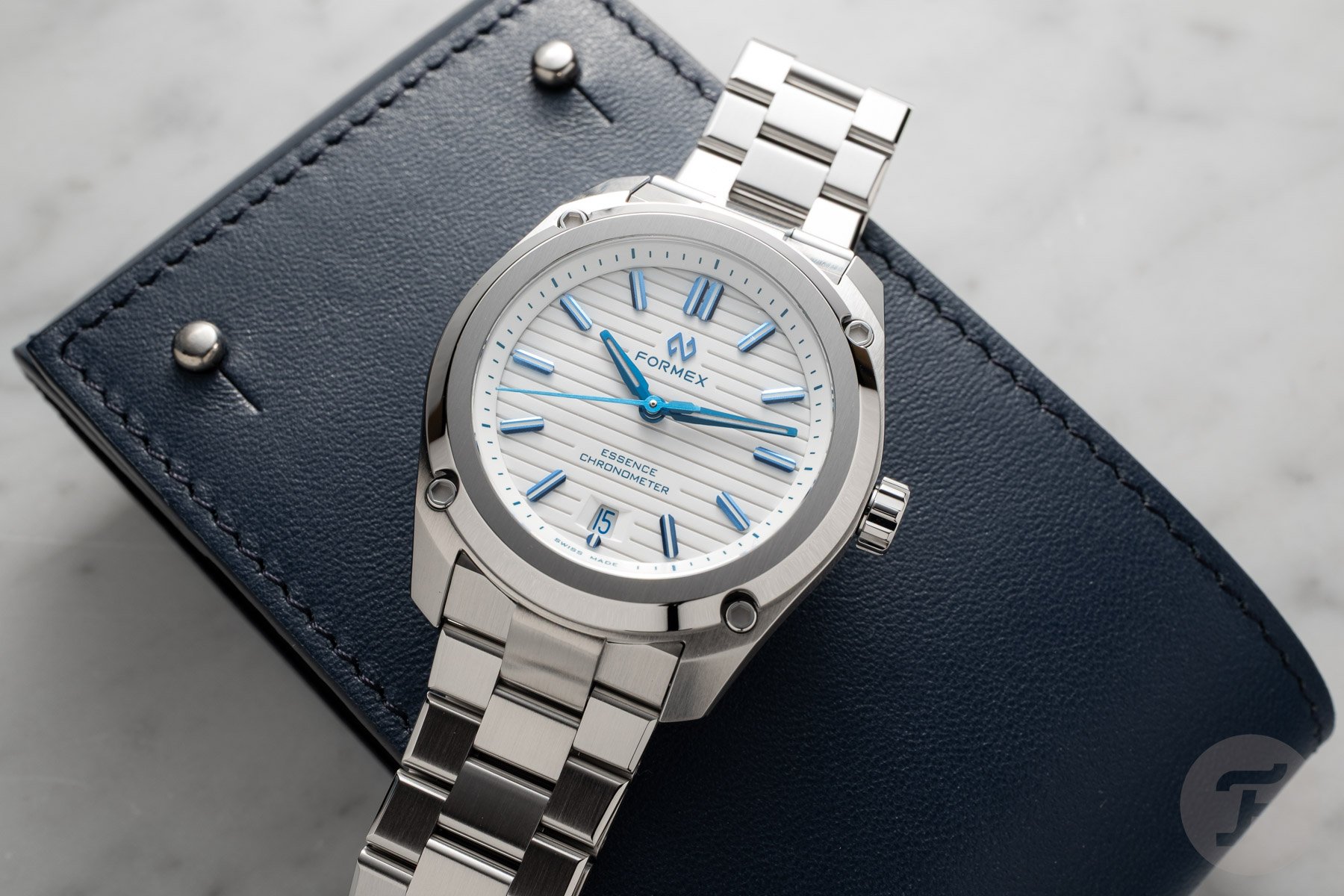 updated Formex Essence Automatic COSC 39mm Alpine White flat-lay on watch pouch