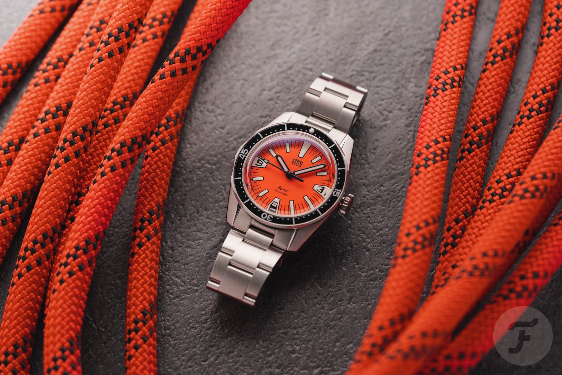 orange-dial HTD Aquatìc SpaceBoy flat-lay with orange rope