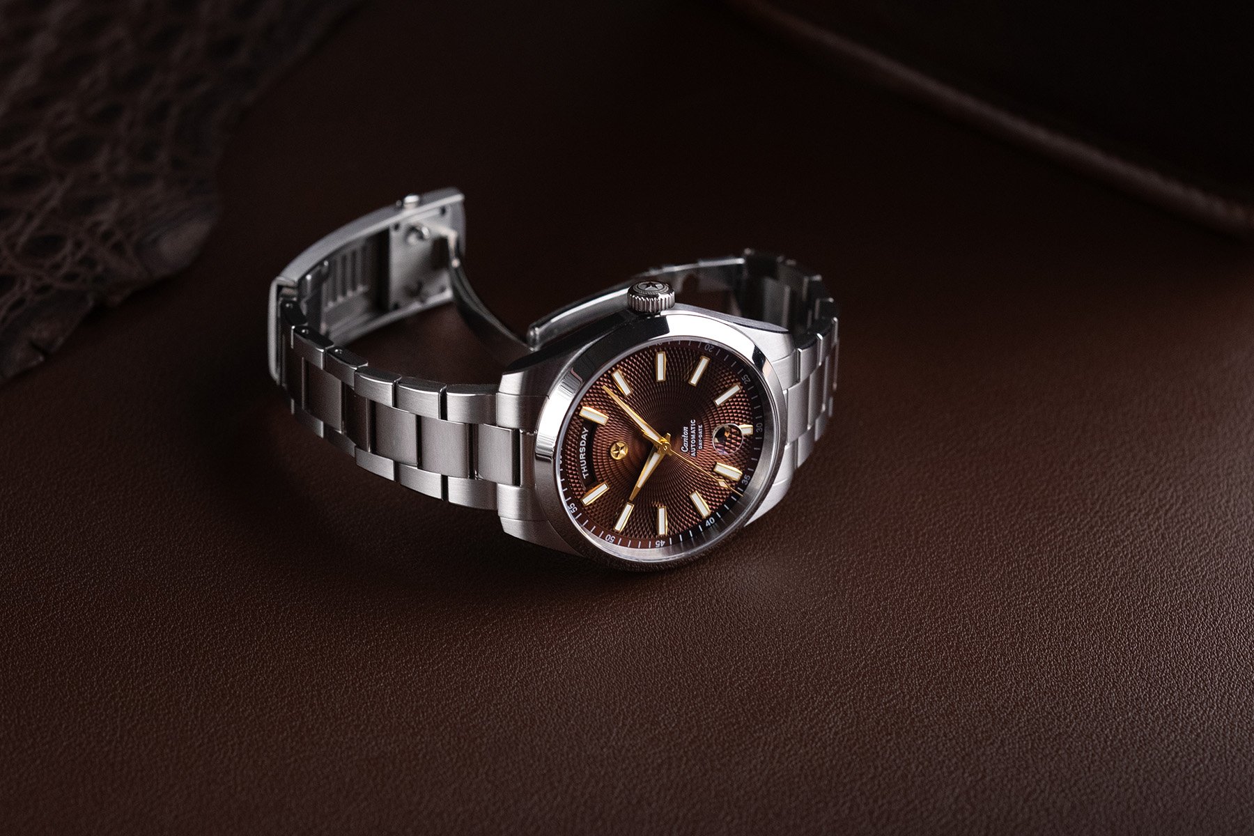 Chocolate-dial Jack Mason Canton Day-Date on its side, crown up