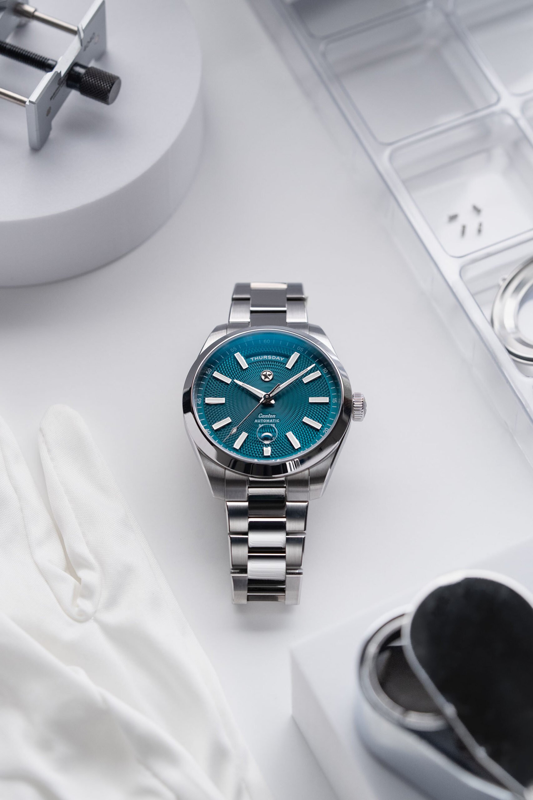 Lagoon-dial Jack Mason Canton Day-Date flat-lay on watchmaking bench