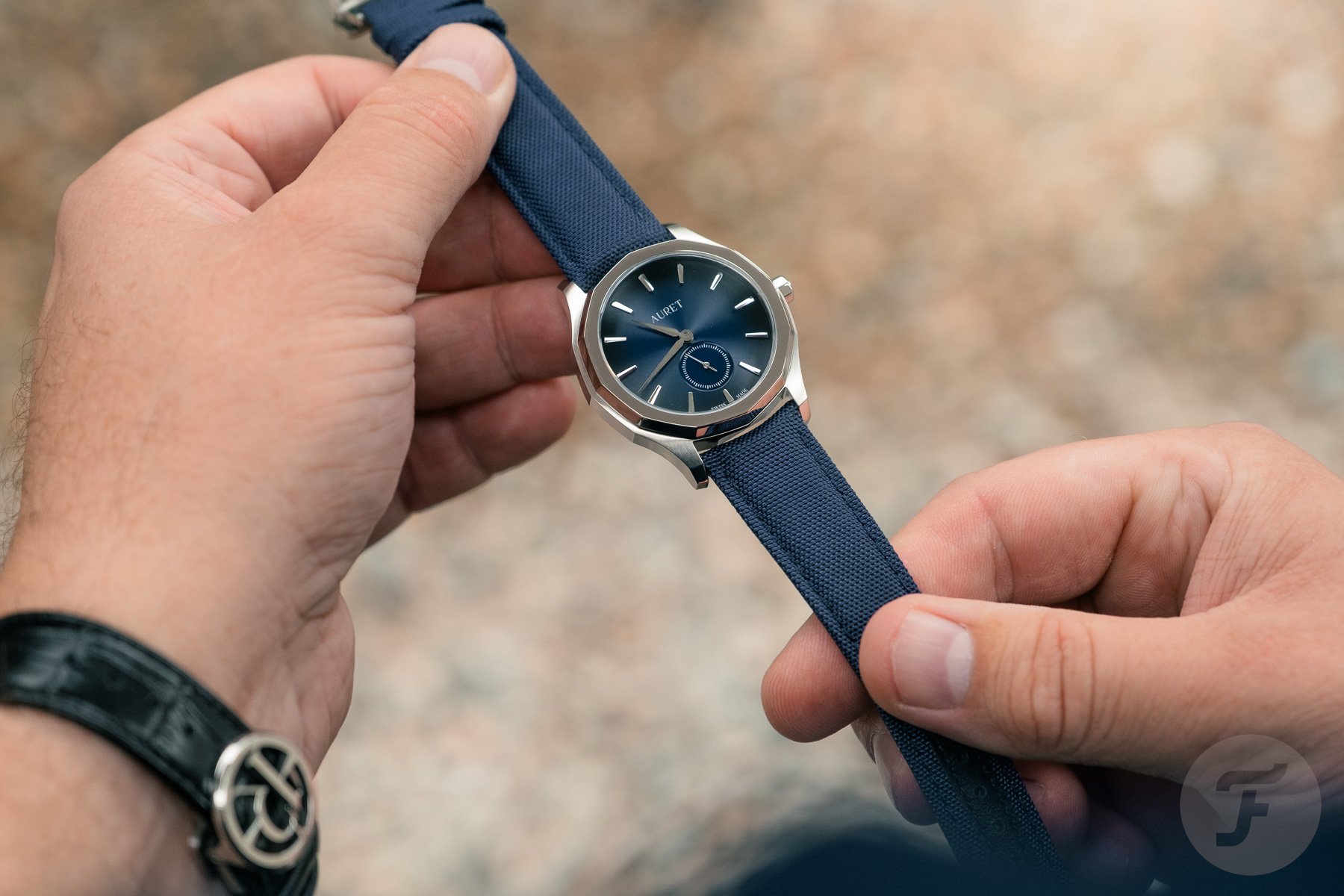 blue-dial Auret Mederi in hands