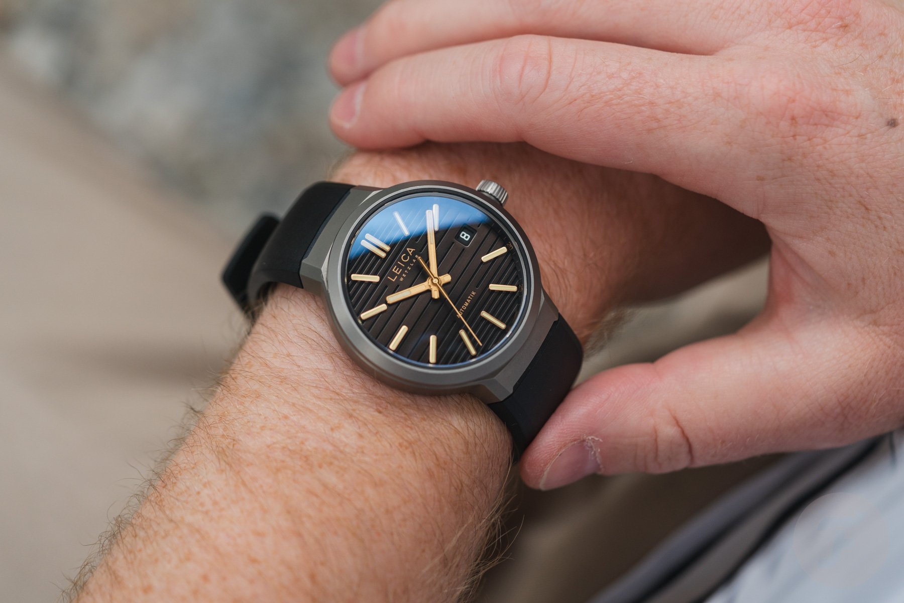 Leica ZM 11 Titanium Coffee Black with rubber strap on wrist
