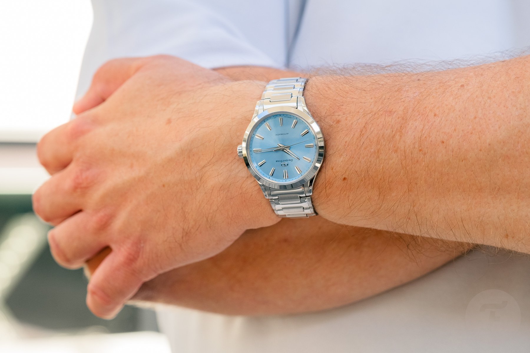 blue-dial Orient Star Sakigake Three Hand on wrist, arms crossed