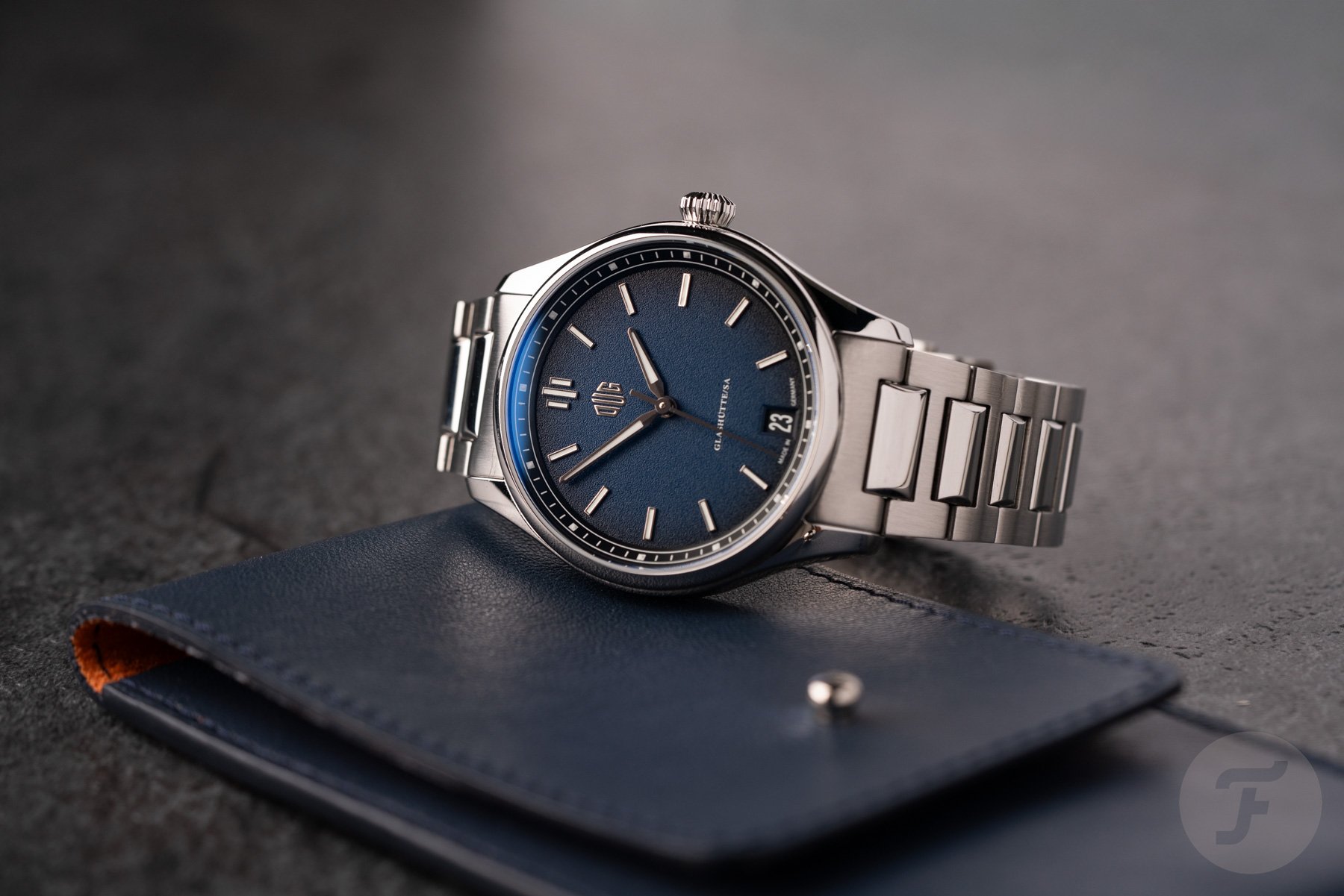 blue-dial DUG Purist Typ 1 on its side, crown up, on top of watch pouch