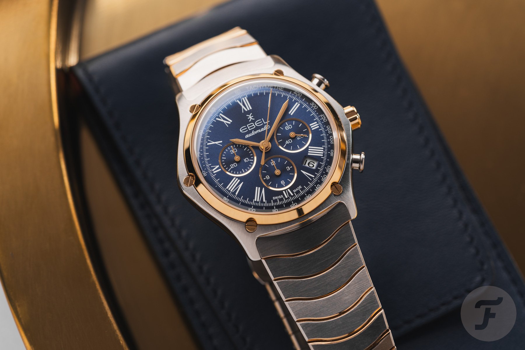 steel-and-gold blue-dial Ebel Sport Classic Chronograph LE on top of watch roll