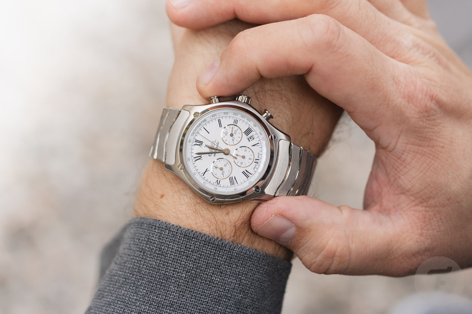steel white-dial Ebel Sport Classic Chronograph LE on wrist, finger on pusher