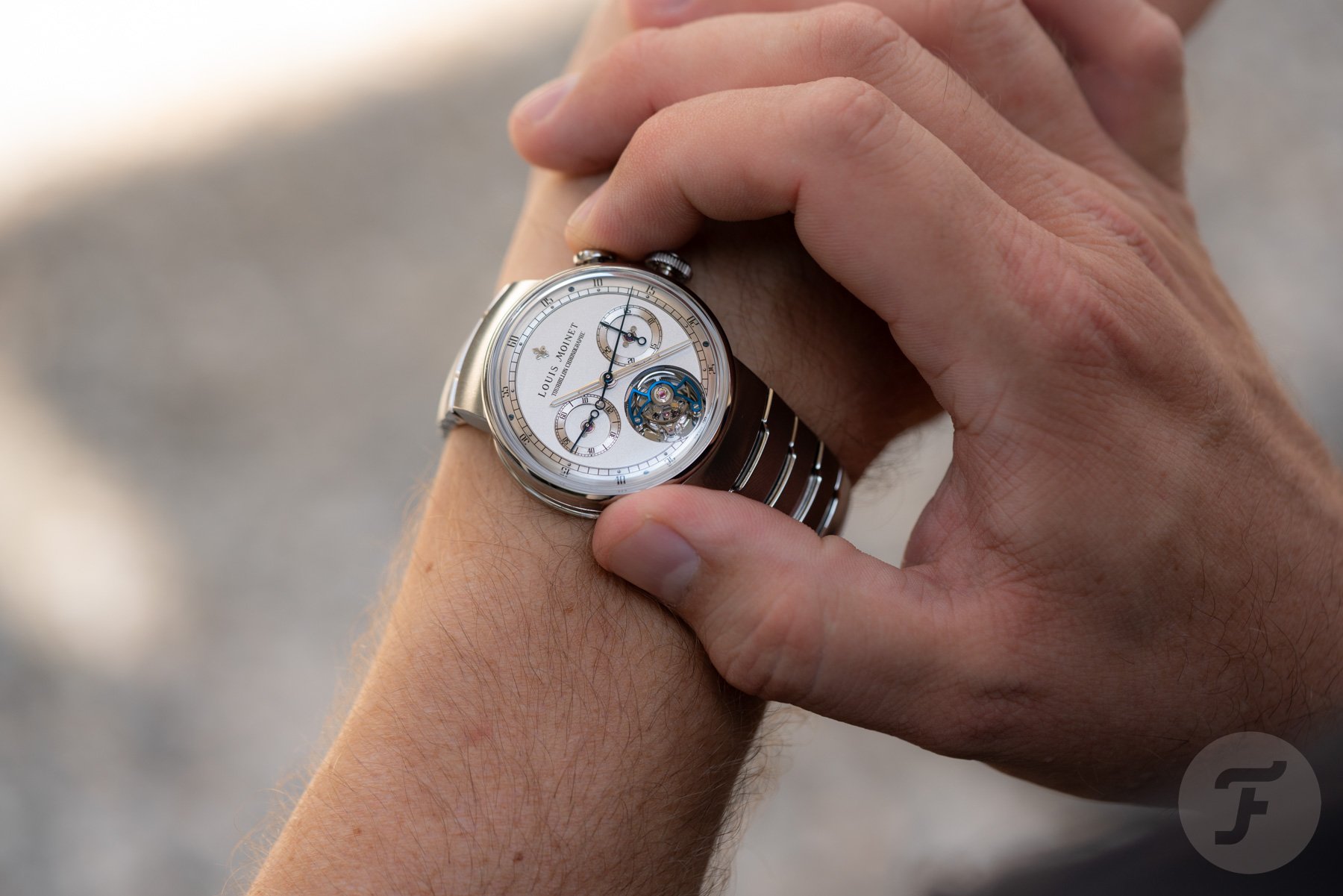 Lower half of the dial of the Louis Moinet 1816 Tourbillon Chronograph on wrist, finger on pusher