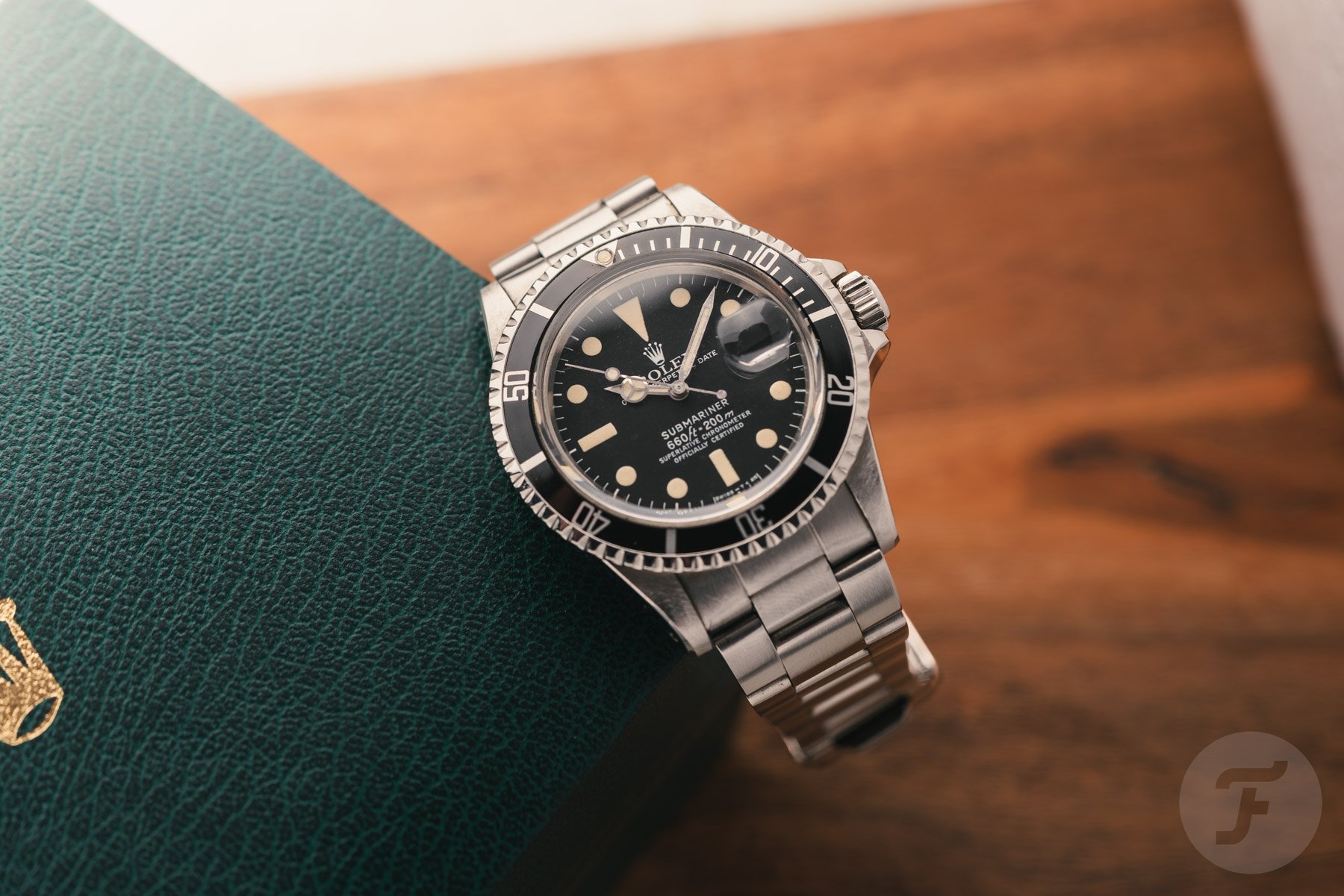 Rolex Submariner Date 1680 hanging off edge of Rolex box